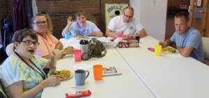 Adults eating food at a table at Hollis Adams