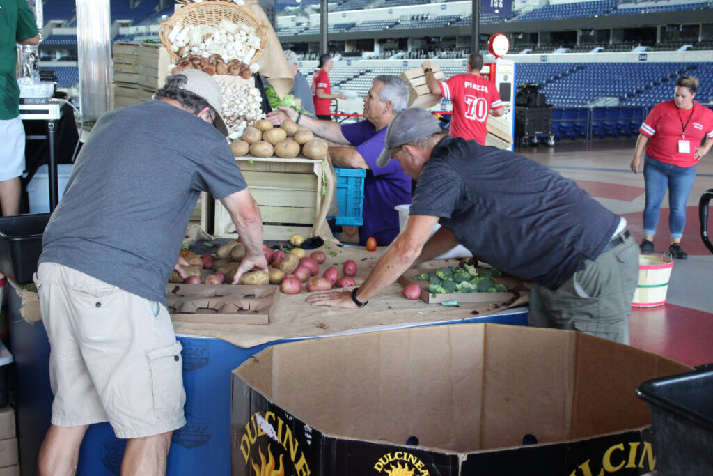 Staff and volunteers rescue produce from a display from an event