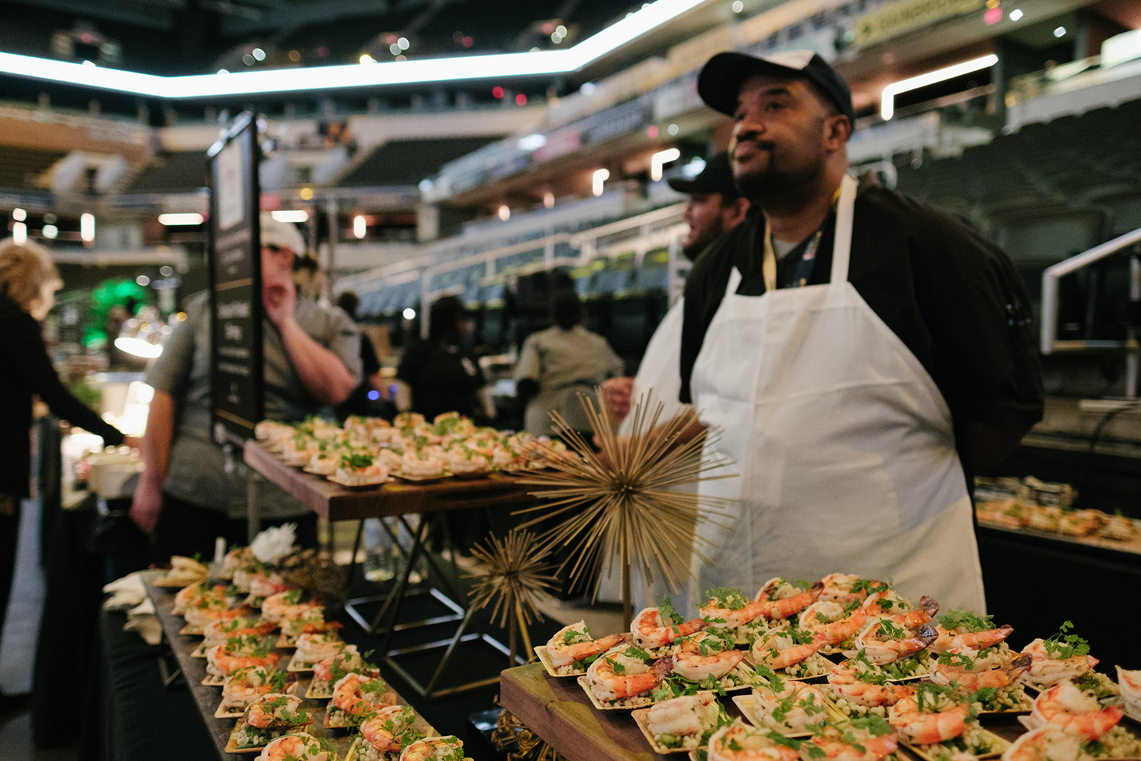 chef standing next to a table full of food